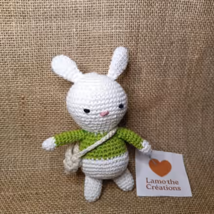 Polo, petit lapin blanc au crochet avec un pull vert