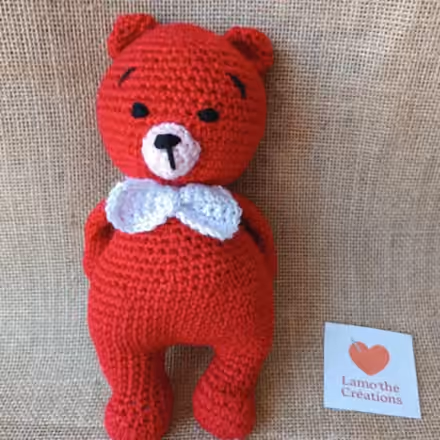 Rubis, ourson rouge au crochet avec un nœud papillon blanc